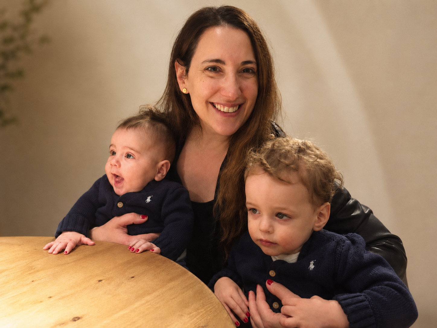 Allison Cohose smiling with her two young sons at a kitchen table